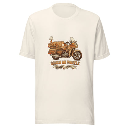An illustrated 1980s Honda Goldwing featuring a floral couch as the seat, an end table, and a lamp mounted on the rear luggage, with the text Couch On Wheels, Comfort For Miles.