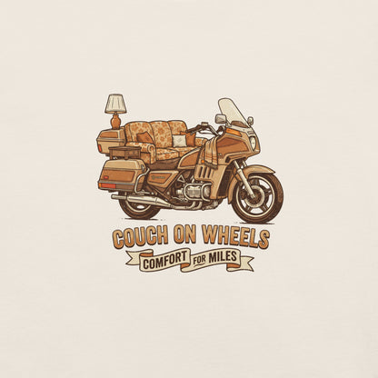 An illustrated 1980s Honda Goldwing featuring a floral couch as the seat, an end table, and a lamp mounted on the rear luggage, with the text Couch On Wheels, Comfort For Miles.