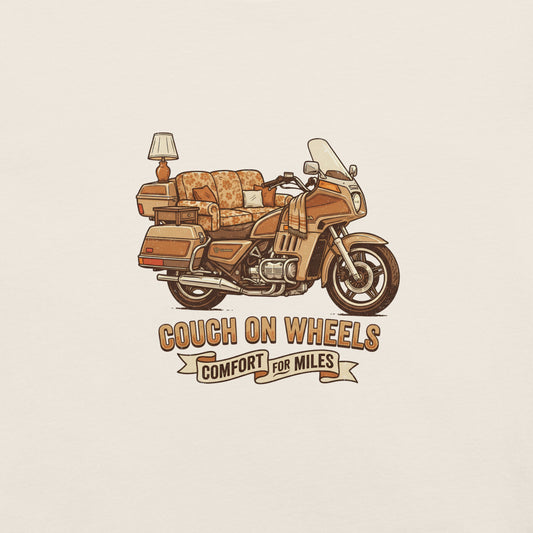 An illustrated 1980s Honda Goldwing featuring a floral couch as the seat, an end table, and a lamp mounted on the rear luggage, with the text Couch On Wheels, Comfort For Miles.